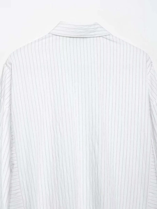 Detail of vertical pinstripes and stitching on the back yoke of a white cotton shirt