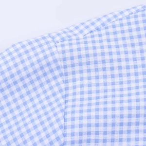 Detail of blue and white gingham shirt showing clean shoulder seam stitching and fabric texture