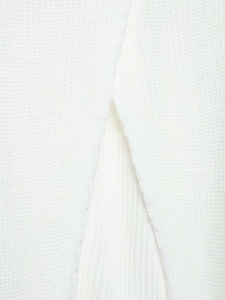 Close-up of white knitted sweater showing detailed vertical ribs and split hem design