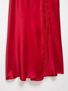 Detail of red satin dress featuring elegant eyelash lace trim and silky fabric texture