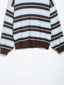 Detail of blue and brown striped knit sweater showing ribbed cuffs and textured fabric