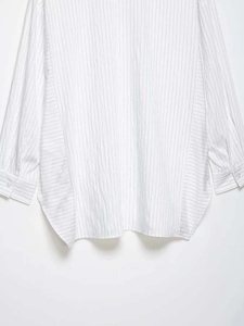 Detail of white pinstripe shirt featuring vertical stripes and side panel contrast