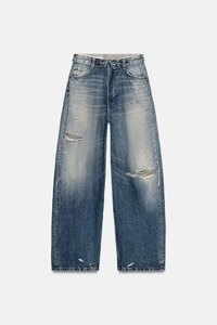 Detail view of vintage light blue wide-leg jeans with double-waistband and distressed holes
