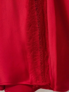 Detail of red satin dress featuring delicate eyelash lace trim on the garment edge