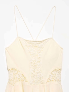 Detailed view of yellow camisole dress with white floral lace trim and thin straps