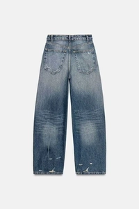 Detail of vintage high waist wide leg jeans featuring distressed wash and back pockets