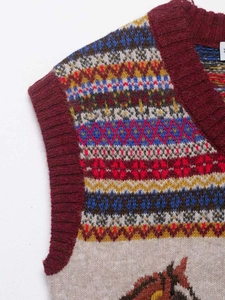 Detail of vintage Fair Isle knit vest with multi-color geometric patterns and horse motifs