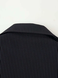 Close-up of lapel detail on a black pinstripe suit with professional woven texture