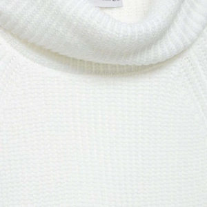 Minimalist white high-neck knit sweater with side slits and textured ribbed fabric finish