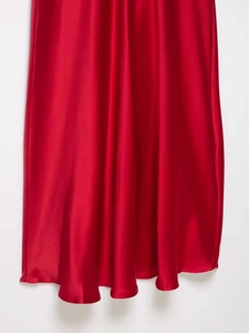 Detail of red satin dress featuring smooth silky texture and natural draped folds