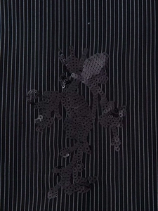 Close-up of black pinstripe blazer fabric with luxury sequin floral embroidery details