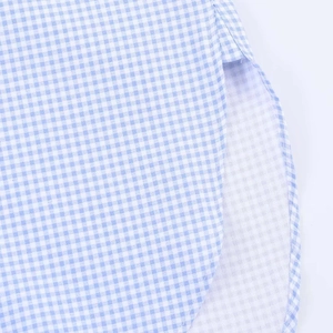 Detailed close-up of blue and white gingham shirt featuring side slits and curved hemline