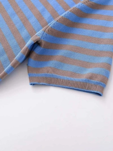 Detailed close-up of blue and brown striped knit sweater with ribbed cuffs texture