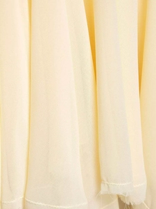 Detail of light yellow chiffon fabric showing fine grain texture and soft drape pleats