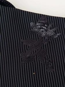 Macro shot of black pinstripe blazer fabric with sequin floral embroidery detail
