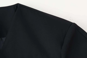 Detail of shoulder stitching and fine woven fabric texture on black V-neck blazer