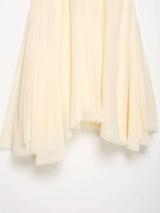 Detail of light yellow summer dress showing the artistic raw hem and lightweight fabric