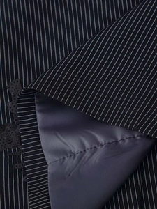 Detail of pinstripe fabric with black sequins and smooth satin lining on a blazer