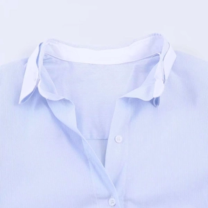 Close-up of blue pinstripe shirt featuring a contrasting white pointed collar and buttons