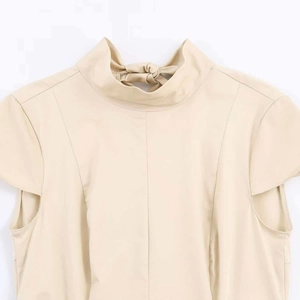 Detail of elegant stand collar and bow tie ribbon on the back of beige sleeveless dress