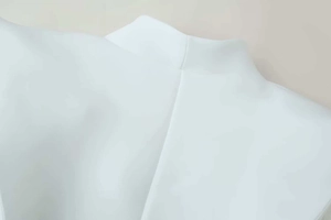 Detail shot showing precise stitching on the back of a white tailored blazer's collar