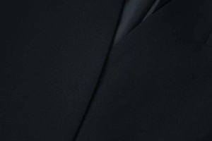 Detailed close-up of premium black blazer showing fine texture and smooth inner lining