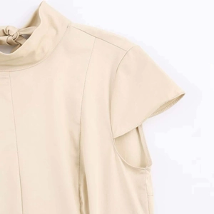 Detail of beige high neck dress with back bow tie and delicate flutter sleeves