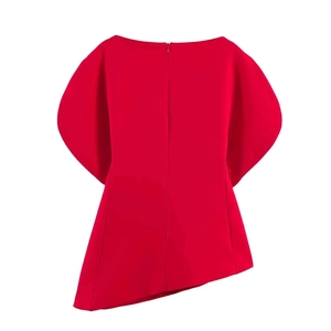Détail du haut rouge à épaules dénudées avec manches volantées et coupe asymétrique