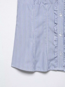 Detail of blue and white striped shirt featuring ruffle trim and white buttons