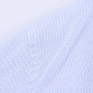 Detailed macro shot of light blue striped shirt fabric with high-quality stitching detail
