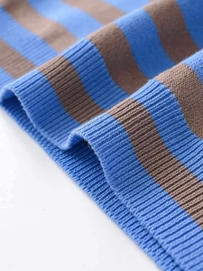 Close-up of blue and brown striped knitwear showing ribbed hem and soft fabric texture