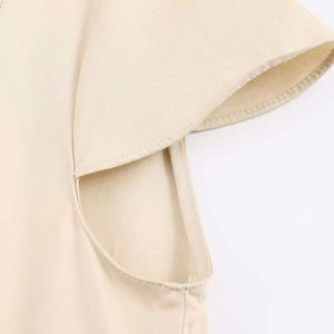 Detailed close-up of stitching and twill weave texture on a beige cap sleeve dress