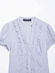 Detail of blue and white striped shirt featuring V-neckline and ruffle trim details