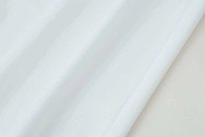Vue macro de la texture du tissu sergé blanc avec plis élégants et reflets naturels