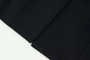 Close-up of fine stitching and woven texture on a black V-neck long sleeve blazer