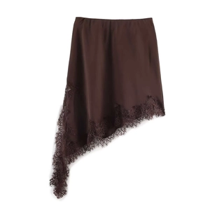 Détail de la jupe en satin marron avec ourlet asymétrique et bordure en dentelle