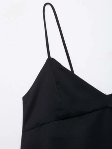 Close-up of minimalist black V-neck camisole top with thin shoulder straps in soft fabric
