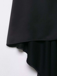 Detail view of black V-neck top showing irregular hemline and premium stitching