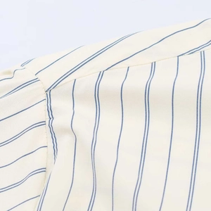 Detailaufnahme der beigen Nadelstreifen-Bluse mit Fokus auf Stofftextur und Nähte