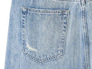 Close-up of light blue denim back pocket with distressed details and double stitching