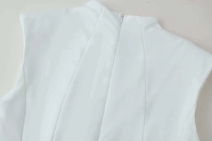 Détail de la robe blanche ajustée avec col montant et fermeture éclair invisible