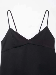 Close-up of black V-neck camisole top featuring thin straps and structural seams