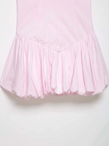 Dettaglio dell'abito estivo in popeline rosa chiaro con orlo a palloncino e pieghettato