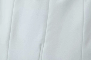 Gros plan du tissu de robe qipao blanche avec texture fine et coutures verticales