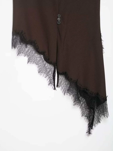 Detail of asymmetrical dark brown hem with black eyelash lace trim and buttons