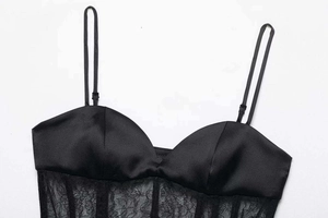 Nahaufnahme von schwarzem Satin-Korsett-Top mit transparenten Spitzeneinsätzen