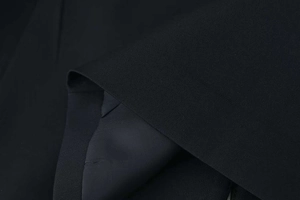 Detail of high-quality black blazer fabric showing precision stitching and crisp texture