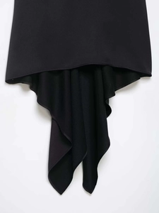 Detail of black top with asymmetric hemline and refined textured fabric drapes
