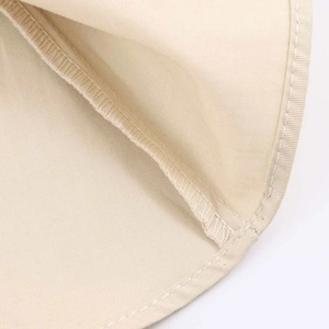 Detailed macro view of the double stitching on beige fabric dress hemline
