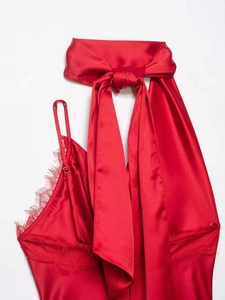 Detail of red satin halter top with lace trim and large decorative bow design
